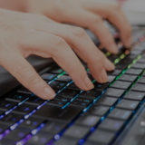 PCのキーボードを指でタッチするイメージ画像